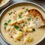 This creamy Roasted Garlic Cheddar Cauliflower Soup is a perfect blend of roasted cauliflower and garlic, finished with sharp cheddar cheese for a rich and flavorful bowl of comfort. Pair it with crusty bread for a delightful meal.