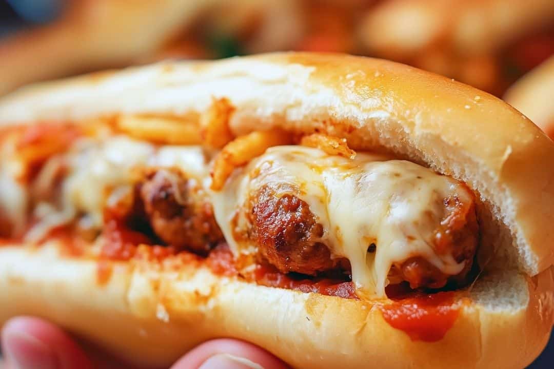 These oven baked meatball sandwiches are loaded with Italian meatballs, marinara, provolone, and mozzarella, baked to perfection in hoagie rolls. A cheesy, hearty meal!