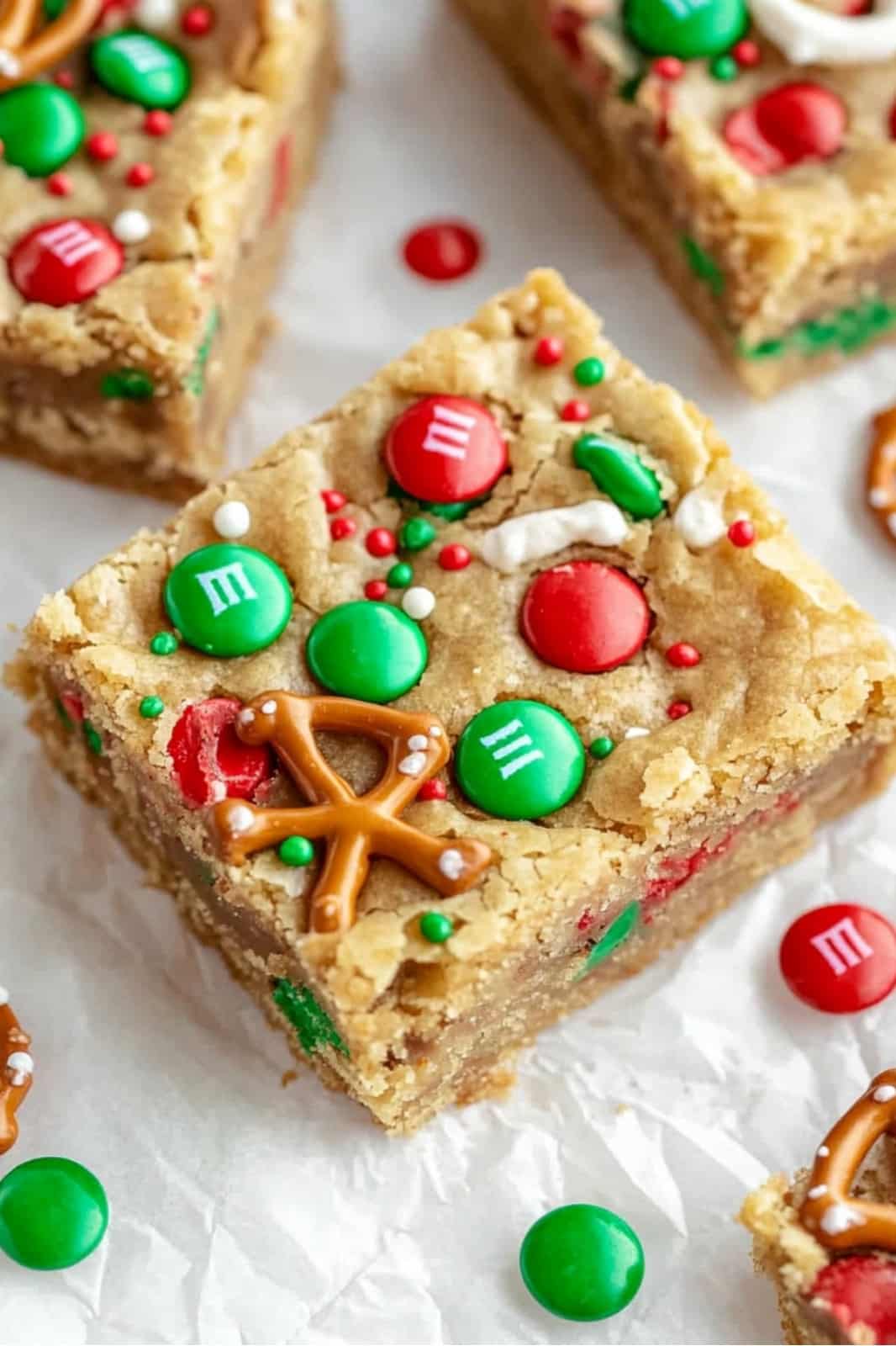 These festive Christmas cookie bars are loaded with chocolate chips, M&Ms, pretzels, caramels, and holiday sprinkles for the ultimate holiday treat. Soft, chewy, and easy to make, they’re perfect for parties or gift-giving!