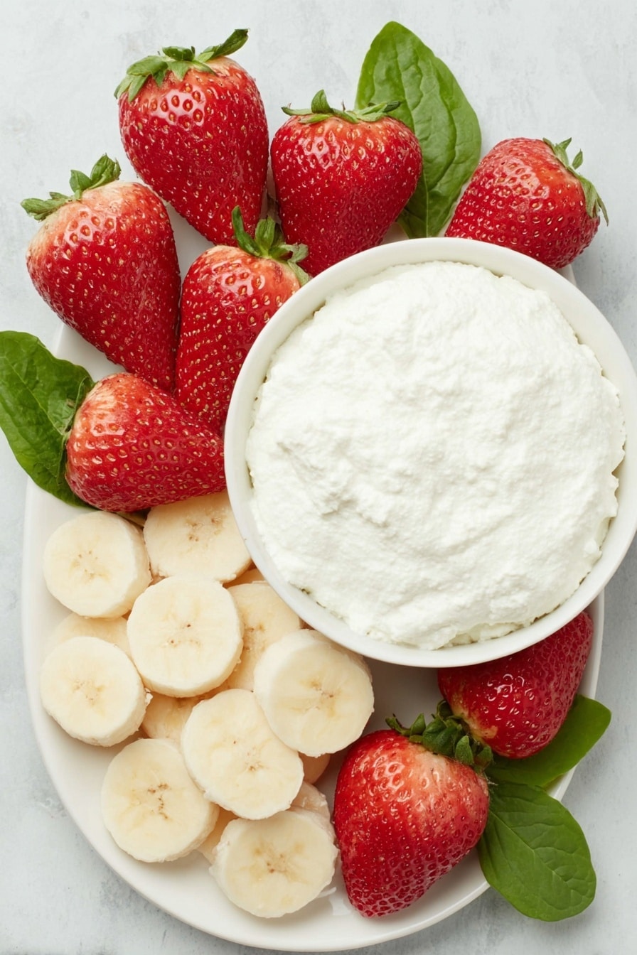 Flat lay of a dozen bright red strawberries with fresh green leaves, a ripe yellow banana sliced into round discs, a small white ceramic bowl filled with creamy white ricotta cheese, all arranged symmetrically on a clean white ceramic plate, placed on a clean white marble surface, soft natural light, photo taken with an iPhone, professional food photography style, fresh ingredients, white ceramic bowls, no bottles, no duplicates, no utensils, no packaging --ar 2:3 --v 7 --p m7354615311229779997 - Healthy Strawberry Santas, festive healthy snacks, quick holiday treats, easy fruit snacks, kid-friendly holiday recipes