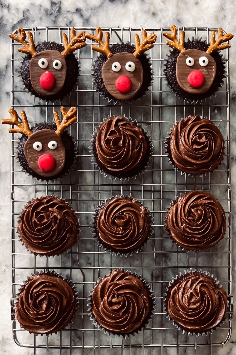 Rudolph Cupcakes with Chocolate and Pretzel Antlers Recipe 6 A metal cooling rack holds twelve chocolate cupcakes on a white marbled surface. Seven cupcakes are decorated as reindeer with a smooth, dark chocolate frosting base, topped with a rectangular chocolate piece for the face, two round white candy eyes, a small round red candy nose, and two small pretzel pieces shaped like antlers, placed near the top edges. The other five cupcakes have swirled dark chocolate frosting, with a textured, soft and creamy look, forming a rose-like pattern on top. Photo taken with an iphone --ar 2:3 --v 7 - Rudolph Cupcakes with Chocolate and Pretzel Antlers, festive holiday cupcakes, reindeer Christmas dessert, adorable holiday cupcake ideas, easy holiday treats