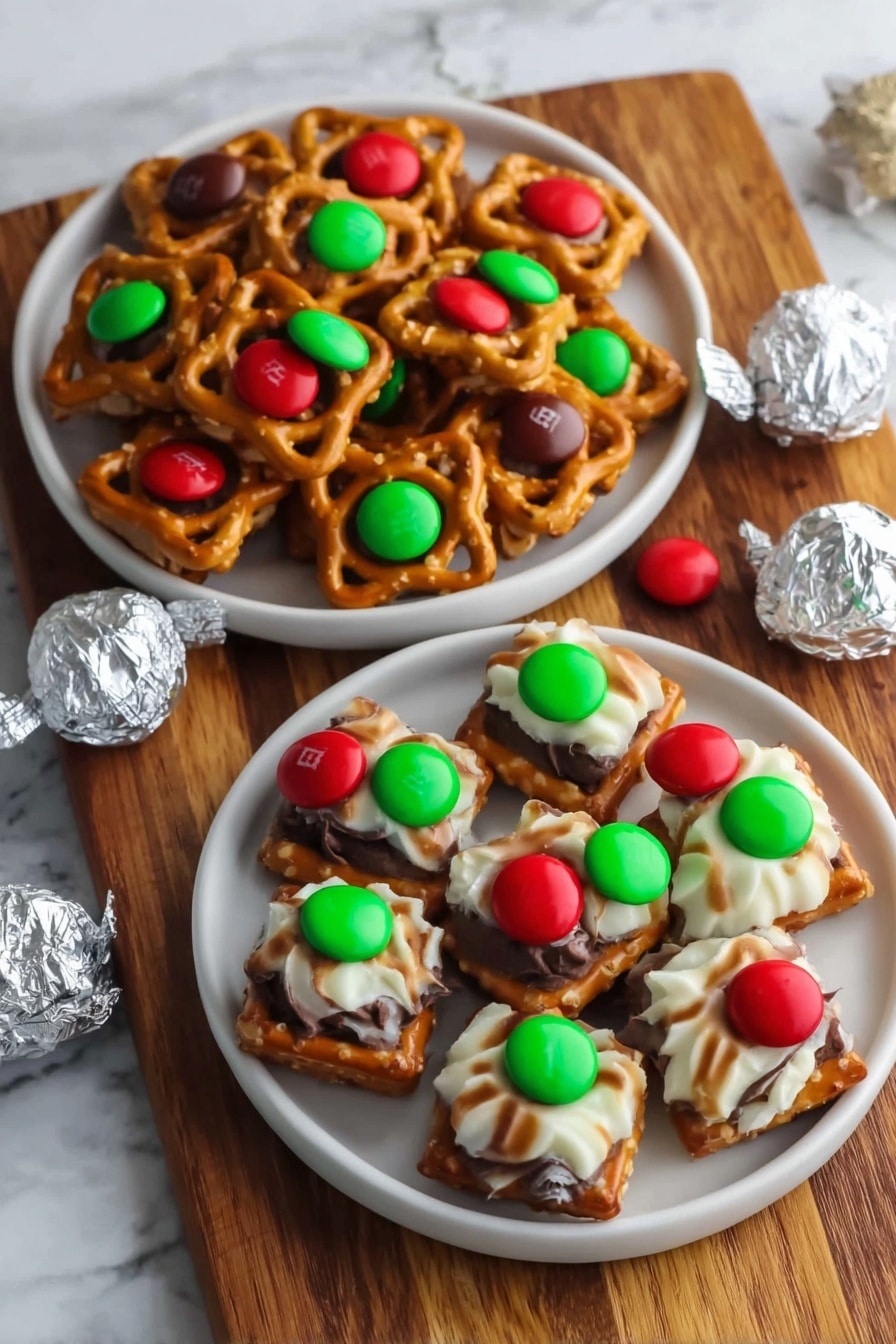 The image shows a close-up view of many small square pretzels laid out neatly on a white marbled surface. Each pretzel has two layers: the base pretzel square is golden brown with a slightly rough texture. On top of each pretzel is either a smooth white and brown striped candy or a round milk chocolate piece. Each candy or chocolate has a small bright red or green candy M in the center, adding a pop of color. The layers are evenly spaced, creating a tidy and colorful pattern. Photo taken with an iphone --ar 2:3 --v 7 - Hershey's Kiss Pretzel Bites, easy chocolate pretzel bites, salty sweet snack recipes, quick party appetizers, simple holiday treats