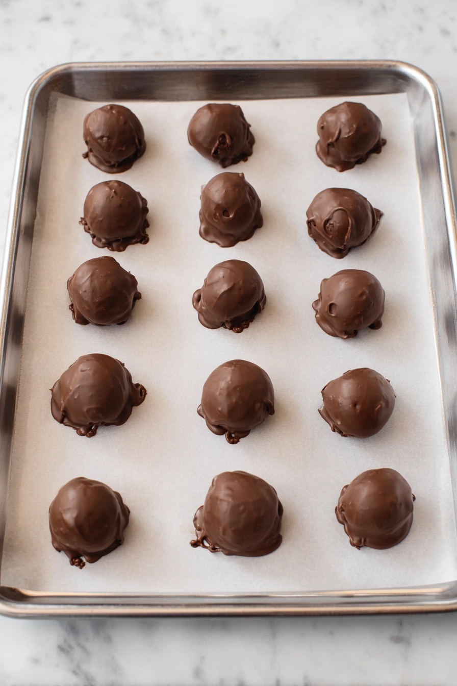 No-Bake Cheesecake Bites with Chocolate Recipe 6 There are several round chocolate balls with a smooth brown outer layer stacked on a wooden board. Each ball is decorated with thin white stripes running down the top and colorful small candy pieces scattered on them and around the board. The top chocolate ball has a bite taken out, revealing a creamy white inside layer. In the background, to the left, there is a clear glass bowl filled with the same colorful candies, and to the right, there is a white plate holding more chocolate balls. The surface under everything is a white marbled texture. photo taken with an iphone --ar 2:3 --v 7 - No-Bake Cheesecake Bites with Chocolate, easy no-bake cheesecake bites, chocolate dipped cheesecake treats, quick no-bake desserts, creamy cheesecake bites