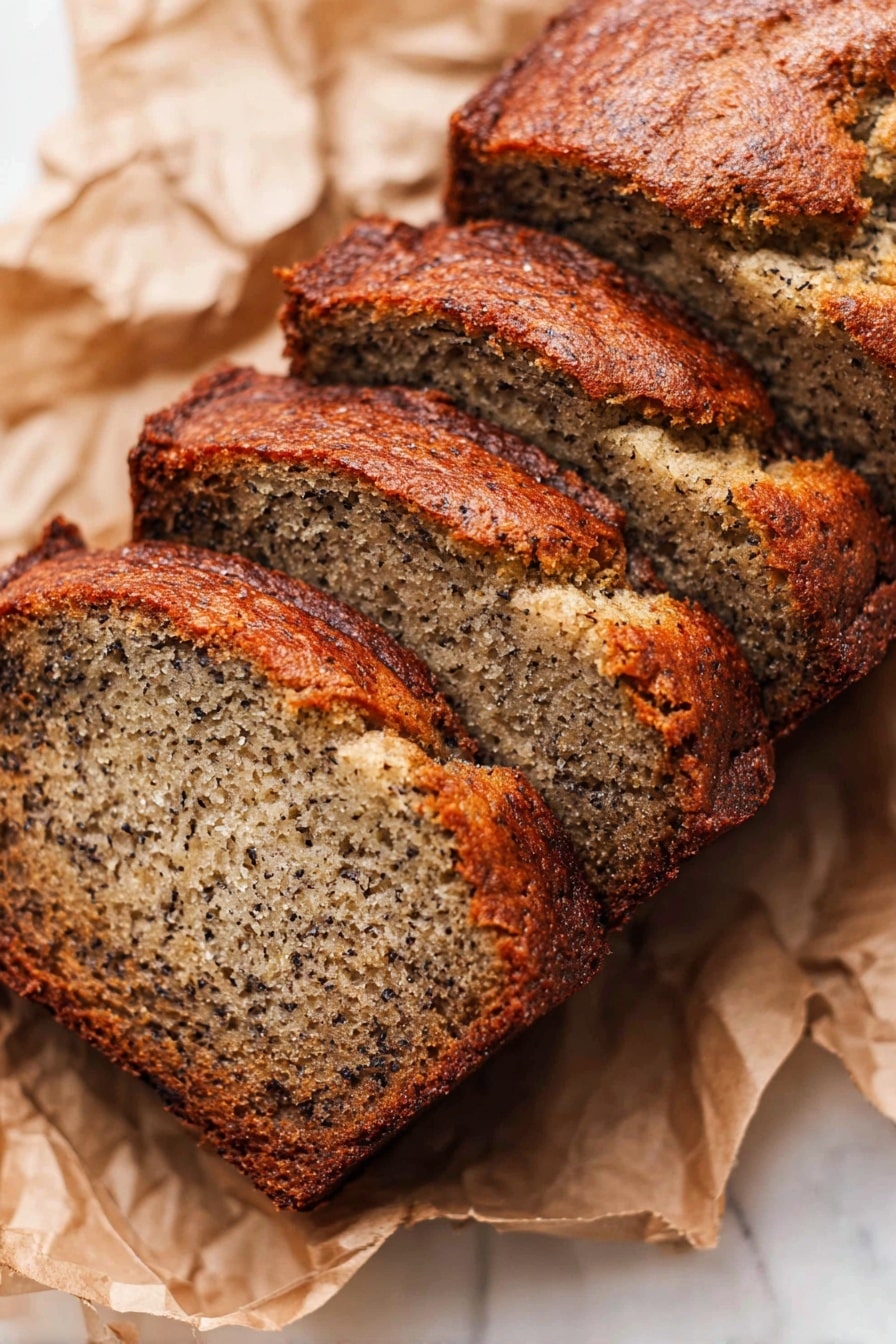 The image shows four slices of banana bread arranged in a slight diagonal line on crumpled brown parchment paper, placed on a white marbled surface. Each slice has a dark golden brown crust with a rough, slightly cracked texture on the edges and top. The inside of the bread is light brown with small dark specks evenly spread throughout, indicating ripe bananas mixed into the soft, moist crumb. The slices are thick and have a slightly uneven, homemade look. The lighting highlights the texture of the crust and the moistness inside the bread. photo taken with an iphone --ar 2:3 --v 7 - Easy Ripe Banana Bread, banana bread recipe, moist banana bread, quick banana bread, simple banana bread