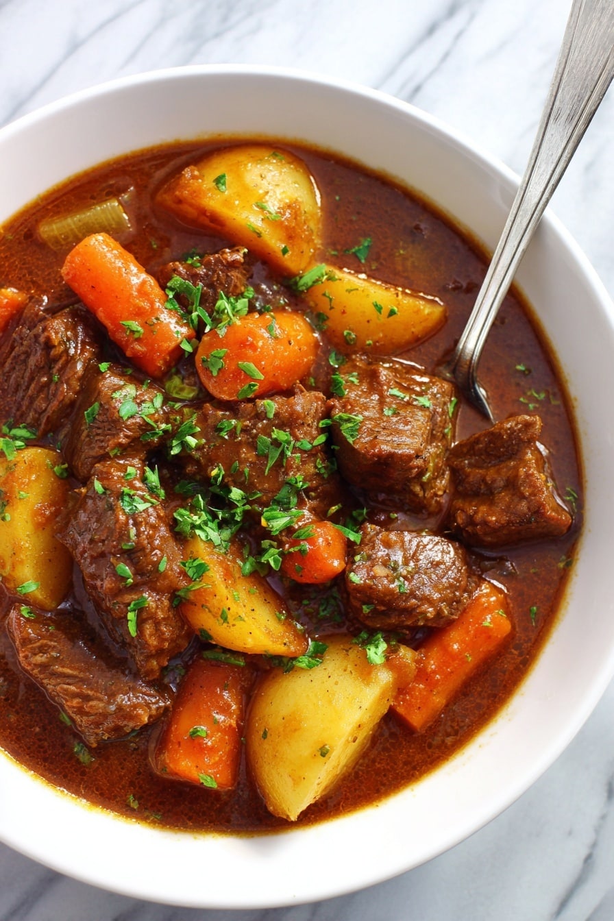This image shows a white bowl filled with a thick beef stew. The stew has many large pieces of brown beef, orange carrot chunks, yellow potato slices, and small pieces of celery mixed in a rich brown sauce. The stew is topped with chopped green herbs. A shiny silver spoon rests inside the bowl. The bowl is placed on a white marbled surface. photo taken with an iphone --ar 2:3 --v 7 - Slow Cooker Beef Stew with Red Wine, hearty beef stew with red wine, easy slow cooker beef recipe, comforting beef stew recipe, tender beef stew with wine