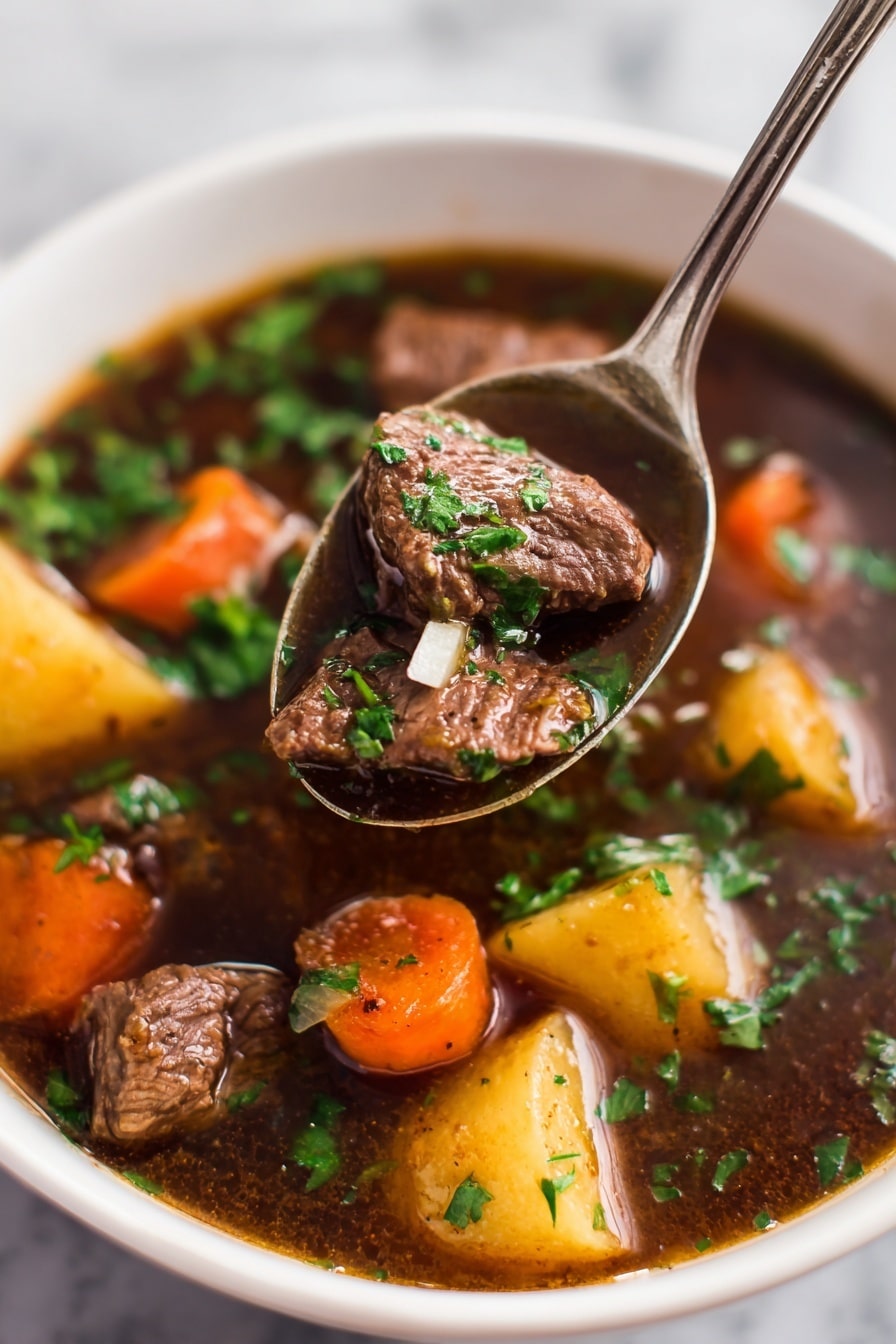 A close-up view of a white bowl filled with beef stew showing three main layers: the bottom layer is dark brown broth that looks thick and rich; above it are medium-sized chunks of light brown beef pieces mixed with orange carrot slices and small yellow potato chunks; the top layer is sprinkled with fresh bright green chopped parsley. A silver spoon holds a large piece of beef with some broth and a tiny piece of onion in the center of the image. The bowl is placed on a white marbled surface. photo taken with an iphone --ar 2:3 --v 7 - Slow Cooker Beef Stew with Red Wine, hearty beef stew with red wine, easy slow cooker beef recipe, comforting beef stew recipe, tender beef stew with wine