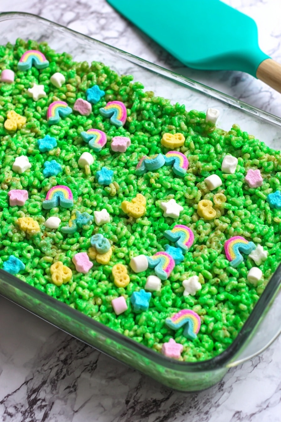 Lucky Charms Rice Krispie Treats Recipe 6 The dish is a single green layer made of puffed cereal tightly packed in a clear glass rectangular dish, with the bright green layer showing a slightly sticky and shiny texture. Scattered evenly on top are colorful, small marshmallow shapes including rainbows, stars, and other shapes in pastel colors like pink, blue, yellow, and white, adding pops of color against the green. The background is a white marbled surface with a teal silicone spatula resting on the upper left edge of the dish. photo taken with an iphone --ar 2:3 --v 7 - Lucky Charms Rice Krispie Treats, colorful cereal treats, marshmallow cereal bars, fun party snacks, nostalgic sweet recipes