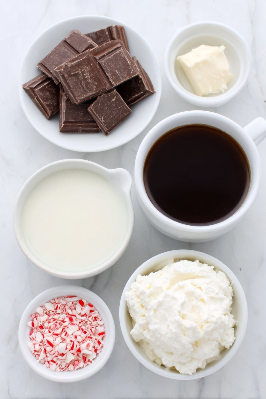Peppermint Mocha Recipe 7 Flat lay of a small white ceramic bowl filled with fresh whole milk, a simple white ceramic cup of dark brewed coffee, a few chunks of chopped bittersweet chocolate neatly arranged on a white ceramic plate, a small white ceramic bowl containing clear peppermint extract, a dollop of freshly whipped cream on a small white ceramic dish, and a small pile of crushed red and white candy cane pieces on another white ceramic plate, all ingredients looking fresh and natural, perfectly balanced and symmetrical, placed on a clean white marble surface, soft natural light, photo taken with an iPhone, professional food photography style, fresh ingredients, white ceramic bowls, no bottles, no duplicates, no utensils, no packaging --ar 2:3 --v 7 --p m7354615311229779997 - Peppermint Mocha, peppermint mocha drink, festive mocha recipe, holiday coffee drink, DIY peppermint mocha