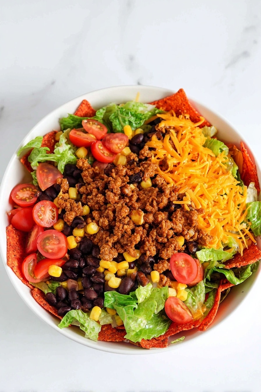 Dorito Beef Taco Salad Bowl Recipe 8 The dish is served in a white bowl placed on a white marbled surface. The bottom layer is made of bright red triangular chips that cover the entire base. On top of the chips, there is a layer of cooked ground meat that is brown and crumbly. Scattered around this are black beans, sweet yellow corn kernels, and fresh green lettuce leaves. Cherry tomatoes, cut in half and showing their red juicy interiors, are spread evenly across the dish. Shredded orange cheddar cheese is sprinkled over everything, adding a final layer of color and texture. Photo taken with an iphone --ar 2:3 --v 7 - Dorito Beef Taco Salad Bowl, taco salad recipes, beef taco salad dinner, crunchy taco salad ideas, quick Mexican salad recipes