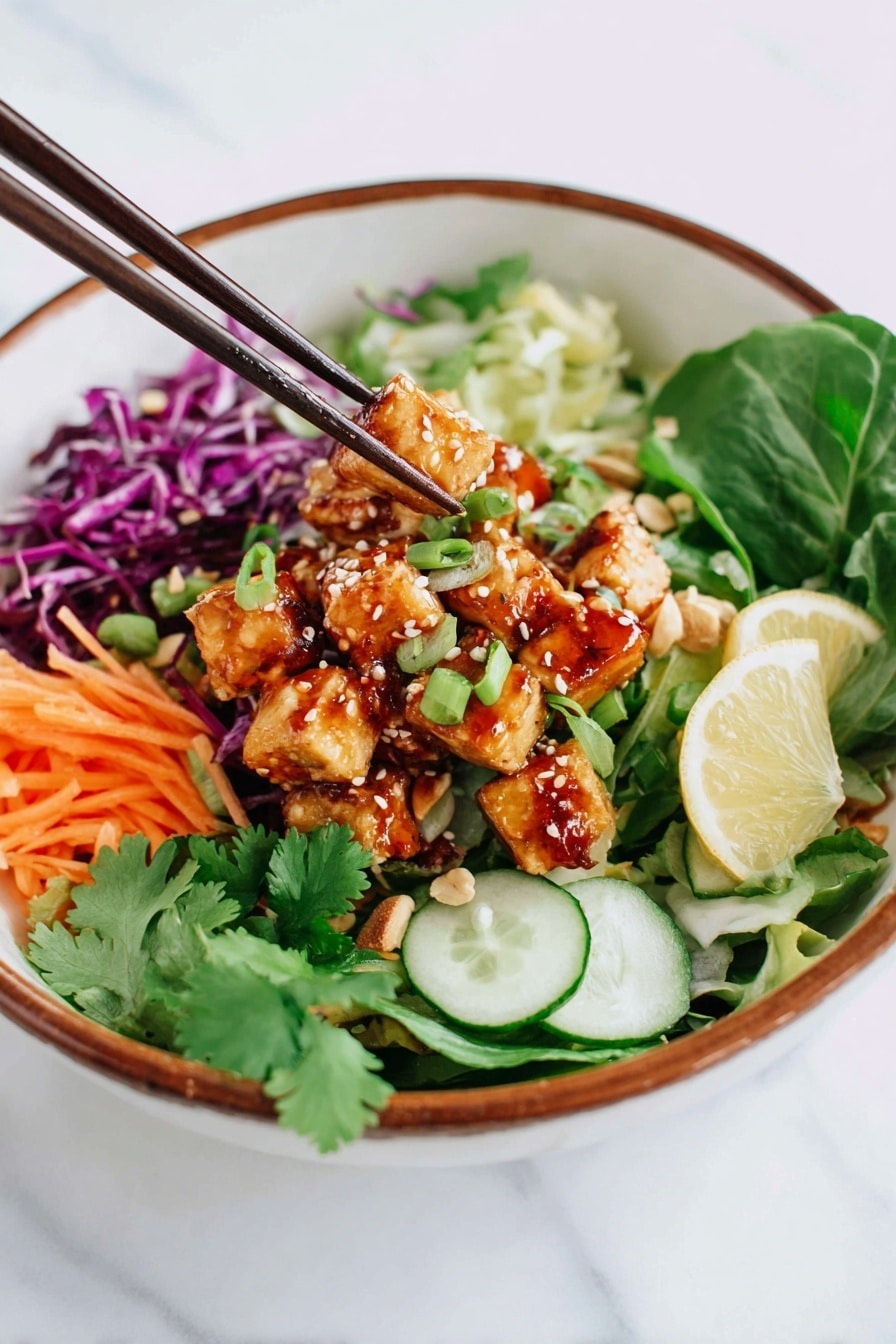 Spicy Tofu Salad Bowls Recipe 8 A white bowl with a brown rim holds a colorful salad arranged in layers; the bottom layer has mixed green leaves and sliced green onions, followed by thin orange carrot sticks and purple cabbage on one side. On top of the vegetables are small golden-brown tofu cubes coated with sesame seeds and chopped peanuts, drizzled with a reddish sauce. There are green cucumber slices and lemon wedges placed around the tofu. A pair of dark brown chopsticks is picking up some tofu from the bowl, and some fresh cilantro leaves garnish the salad. The bowl is set on a white marbled surface. Photo taken with an iphone --ar 2:3 --v 7 - Spicy Tofu Salad Bowls, healthy tofu salads, quick vegan salads, spicy vegetarian bowls, easy tofu salad recipes